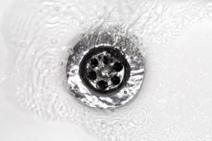 Water flowing down a bathtub drain.